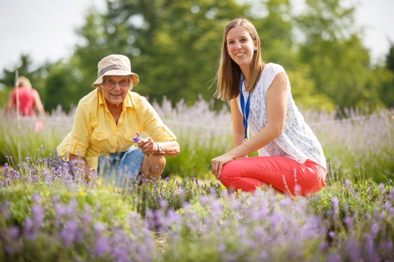 A young woman and an older woman work together in a garden