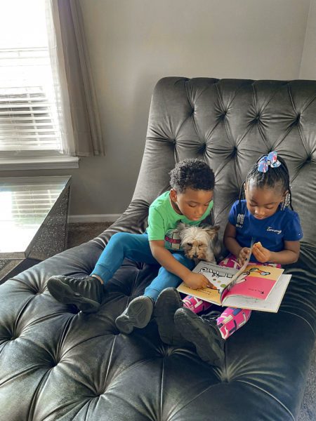 Two children (and a dog!) enjoy a picture book together