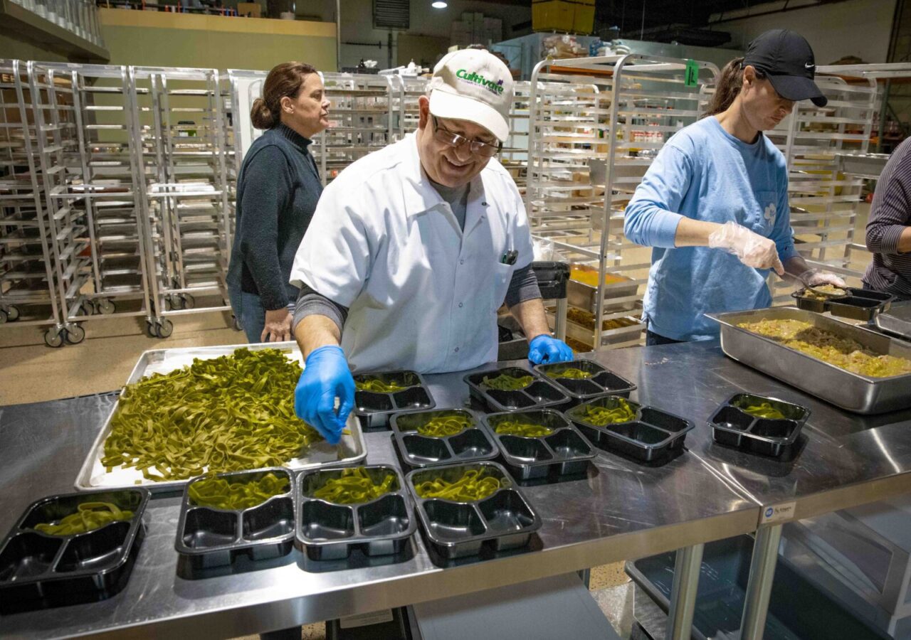 A worker assembles meals at Cultivate Food Rescue