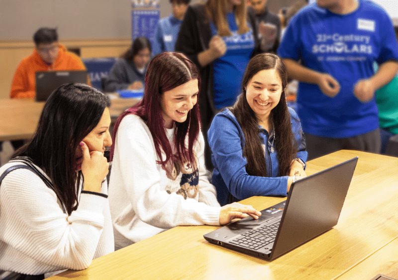 21st Century Success Fellow Alondra Coria works with a high school student and her mother to complete program steps during a recent Success Fest event.