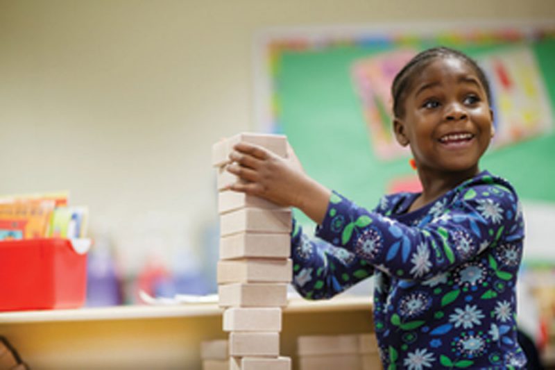 A child plays with blocks in a classroom